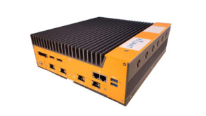 A rugged industrial computer with a ribbed black top, orange sides, multiple Ethernet ports, USB ports, and other connectivity options. The device has a "PLANT" label on the side.