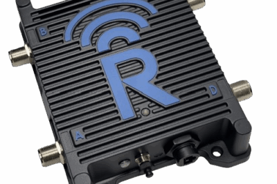 A black electronic device with a large blue "R" and wireless signal icon on top. It has four coaxial ports labeled A, B, C, and D, and additional connectors at the bottom.