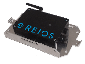 A rectangular electronic device labeled "REIOS" in blue text, mounted on a metallic base with several mounting brackets on the sides.