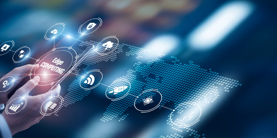 A person’s hand interacts with a transparent touchscreen displaying digital icons and the words “Edge Computing,” with a stylized world map and glowing network connections in the background.