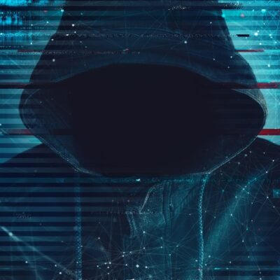 A person wearing a hooded jacket stands in darkness, face obscured in shadow, with digital glitch effects and blue network lines overlaid, suggesting themes of hacking or cybersecurity.