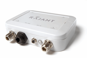 A white Rajant electronic device with labeled ports including Ethernet, power, and coaxial connectors, shown on a plain white background.
