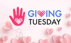 A pink handprint with a heart design and the words "Giving Tuesday" in bold blue and black text. A small figure holds a heart-shaped balloon, surrounded by floating pink hearts on a light background.