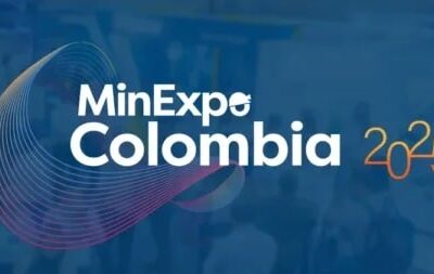 Logo for MinExpo Colombia 2025 overlaid on a blurred background of an exhibition hall, with a multicolored spiral design to the left of the white event name and yellow "2025" text on the right.