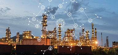 Industrial oil refinery at dusk with illuminated towers and structures. Overlaid digital network icons suggest connectivity and advanced technology integration in the facility.