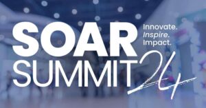 White text reading "SOAR SUMMIT 24" and "Innovate. Inspire. Impact." is overlaid on a blurred background of people walking inside a modern building.