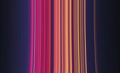 Vertical streaks of vibrant colors, including shades of pink, red, orange, and yellow, blend and flow against a dark purple background, creating an abstract, luminous effect.