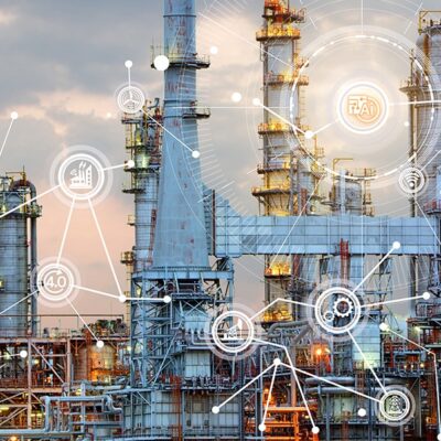 An industrial refinery with tall structures and pipes is overlaid with digital network icons and lines, symbolizing connections, data, and industrial technology integration. Sky is cloudy in the background.