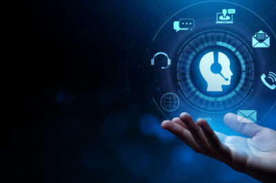 A hand is held out under digital icons representing customer support, communication, email, chat, and headphones, with a glowing silhouette of a person wearing a headset at the center on a blue background.