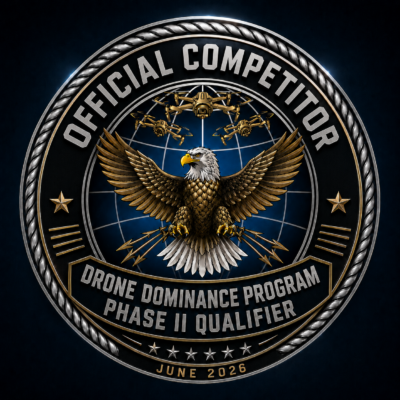A detailed emblem featuring an eagle with drones circling above, surrounded by the text "Official Competitor," "Drone Dominance Program Phase II Qualifier," and "June 2026" on a metallic, badge-like background.